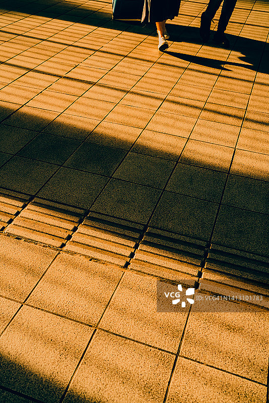 瓷砖地板和行人与夕阳的光影图片素材