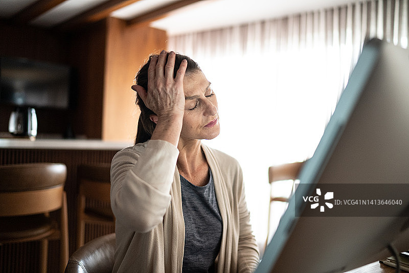 成年女性在家中使用电脑时头痛图片素材
