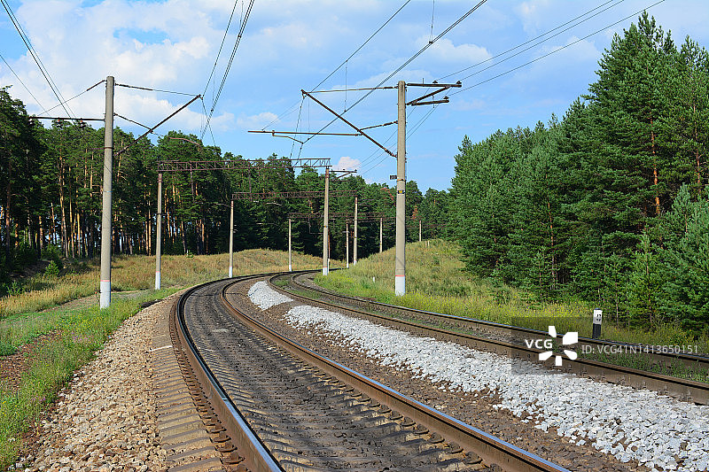 有电柱和电线的铁路和路边的森林图片素材