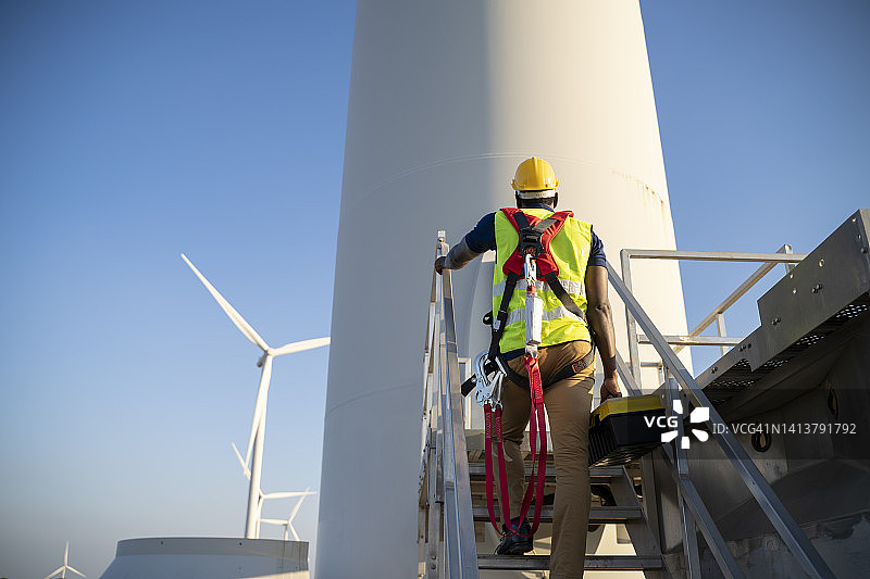 维修涡轮机的风电场技术人员图片素材