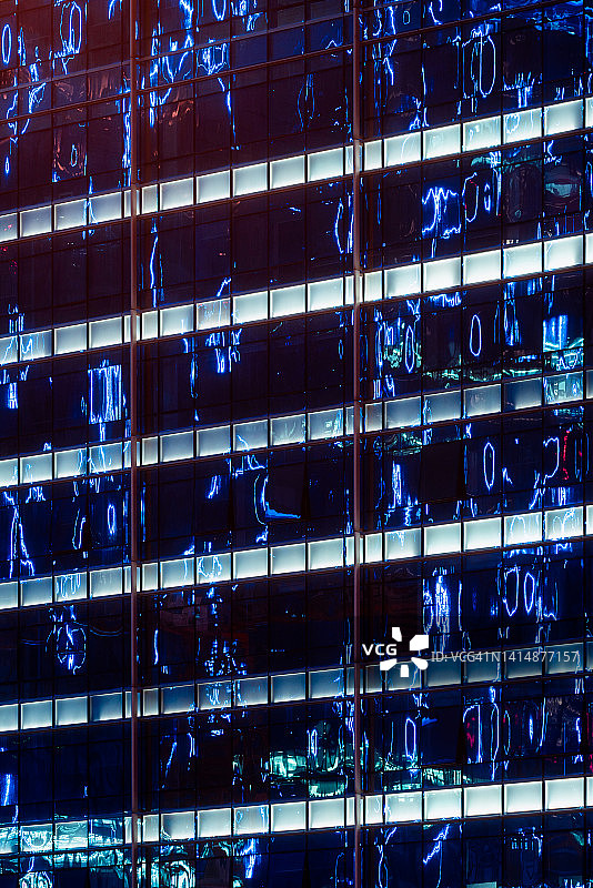 现代玻璃建筑立面在夜晚反射灯光图片素材