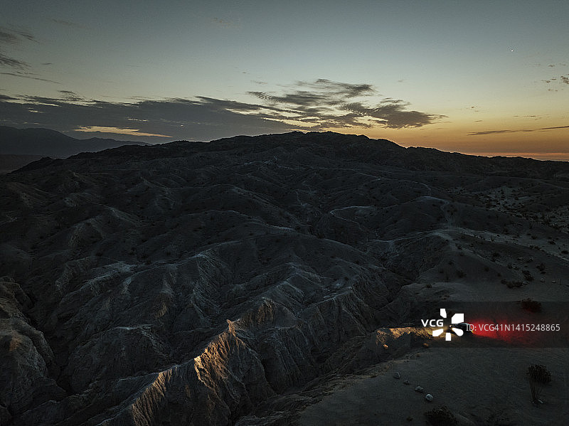 灯光照亮沙漠中的峡谷小径的鸟瞰图图片素材