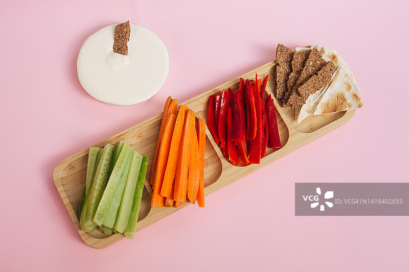健康的素食零食建议:蔬菜或黄瓜、胡萝卜、胡椒、薯片和酸奶蘸酱图片素材