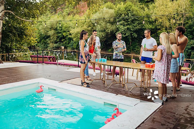 一群人在泳池派对上玩啤酒桌球(一种饮酒游戏)，玩得非常开心图片素材