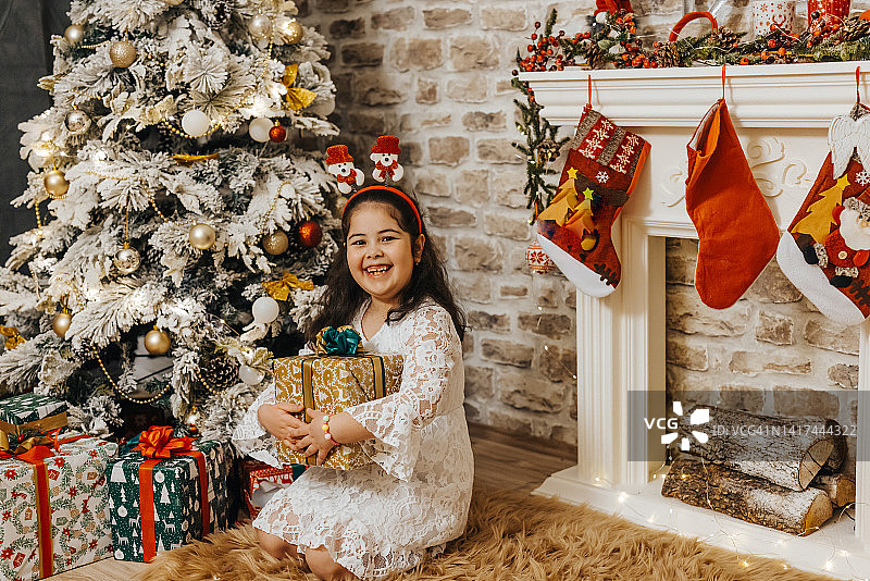 穿着白裙子的快乐女孩在家庆祝圣诞和新年假期图片素材