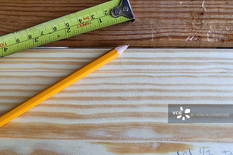 一个黄色的木工卷尺和一支木制铅笔的特写图像图片素材