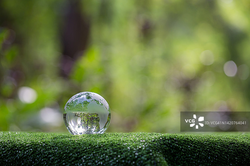 地球玻璃在绿色森林与散景自然灯。世界环境日。以环保理念，保护生态地球，以复制空间保护环保生活图片素材