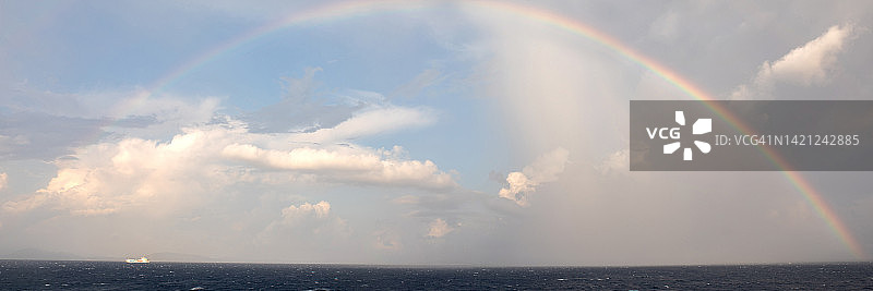整个彩虹在海上和小船附近图片素材