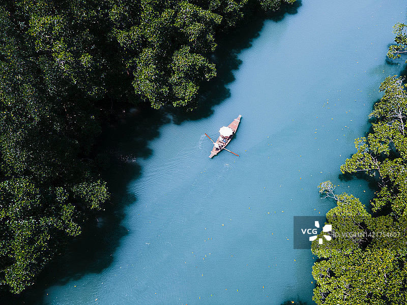 这艘船在泰国达叻的高张，在丰富的红树林中沿着河行驶。图片素材