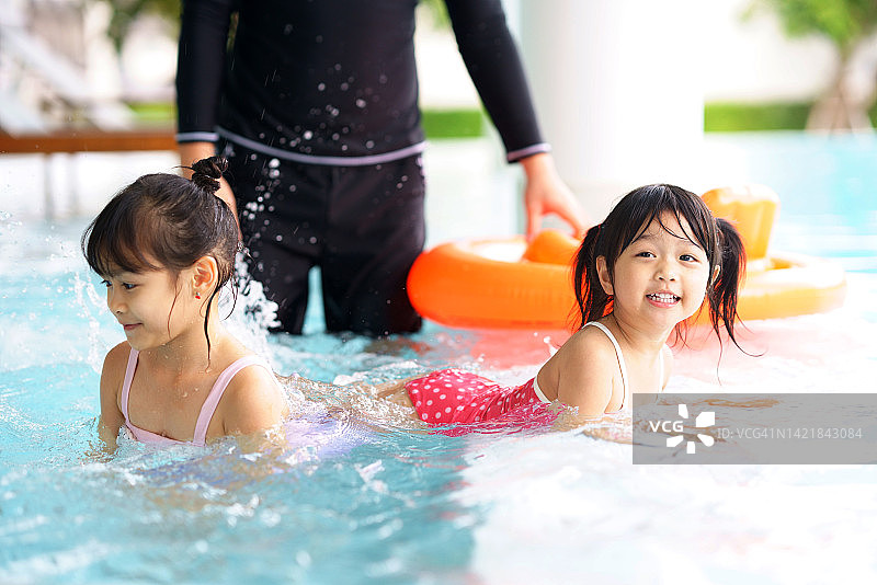 快乐的女孩孩子和朋友在游泳池游泳图片素材