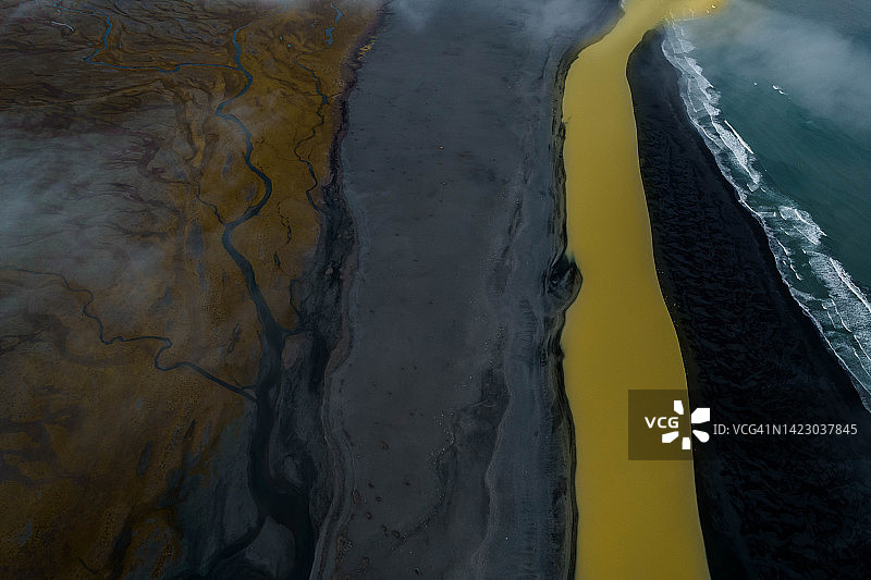 黄色的冰川河在冰岛汇入海洋。图片素材