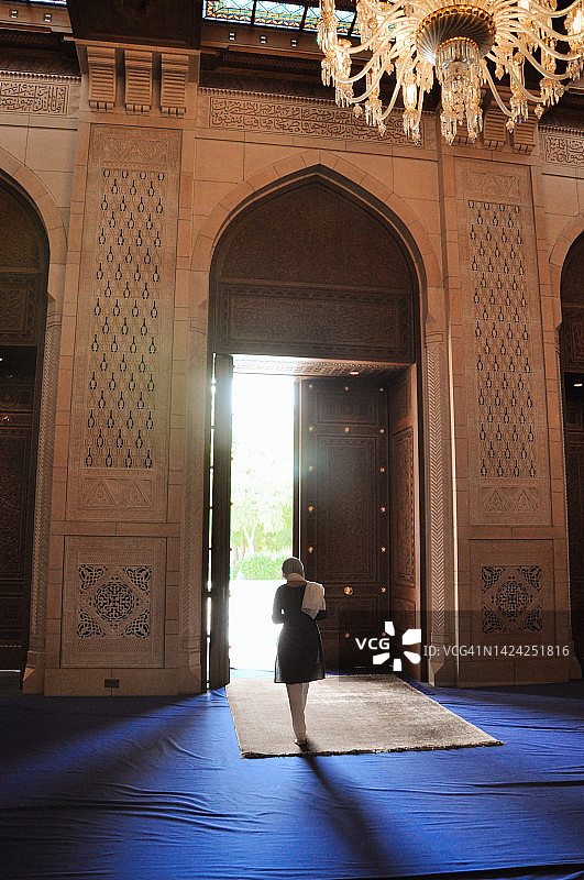 阿曼马斯喀特，一名女子走出苏丹卡布斯大清真寺祈祷厅图片素材