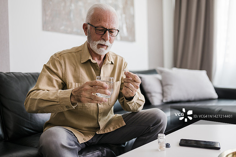 老年男子服用每日剂量的药物图片素材