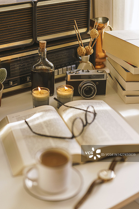 打开书，杯子，咖啡和蜡烛在桌子上图片素材