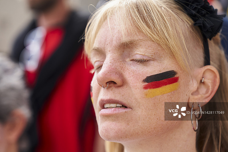 德国女子闭着眼睛观看德国国家队比赛图片素材