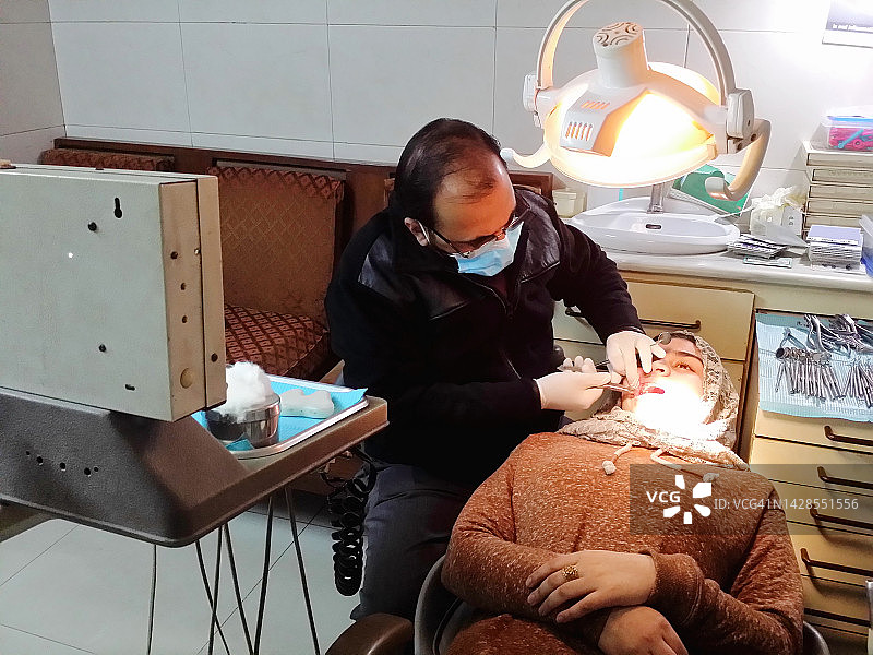 牙科医生在诊所检查少女病人的牙齿。图片素材