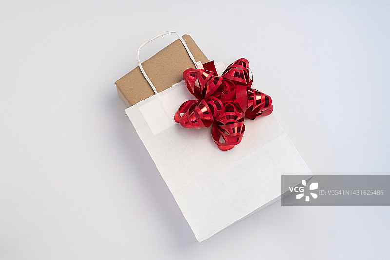 礼盒装在干净的白色纸袋里，带红色蝴蝶结图片素材