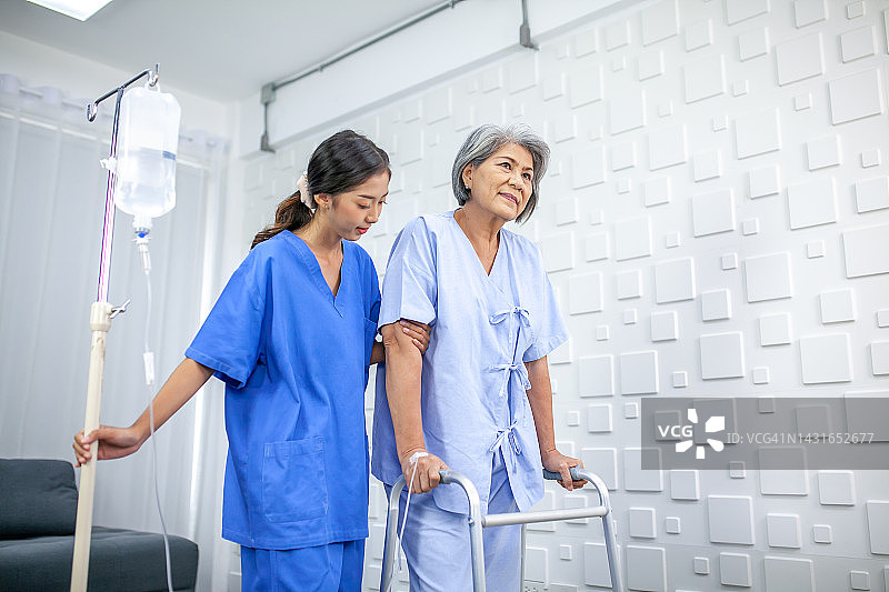 亚洲护士协助老年病人在医院尝试用生理盐水行走，医疗保健和医学概念。图片素材