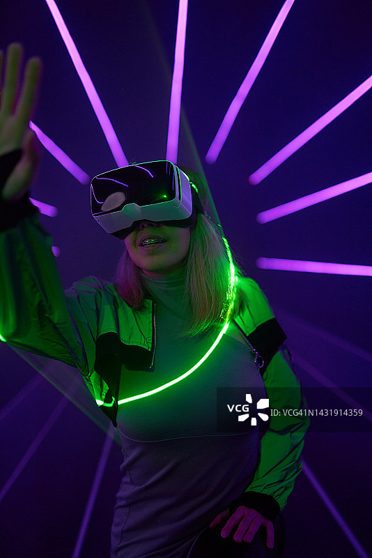 一名女子正在使用虚拟现实头盔进入元世界。图片素材