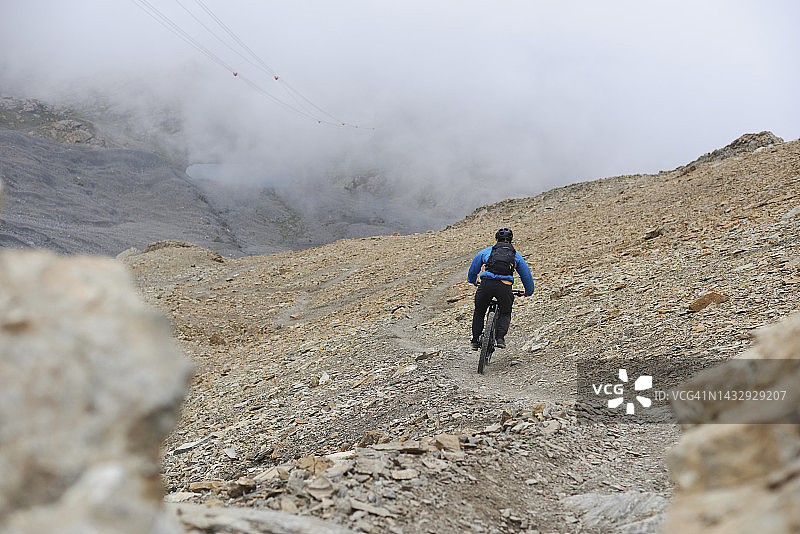 山地自行车手骑在山脊上的狭窄小道上图片素材