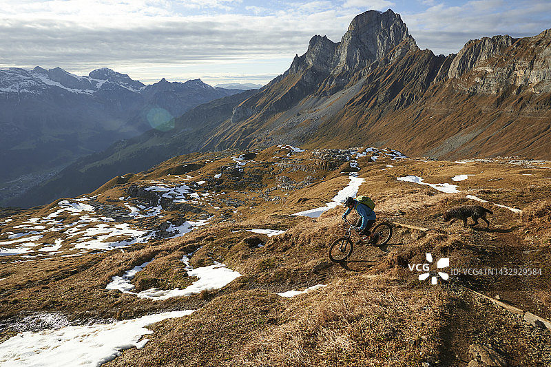 山地车骑手骑在崎岖的山脚下的狭窄小道上图片素材