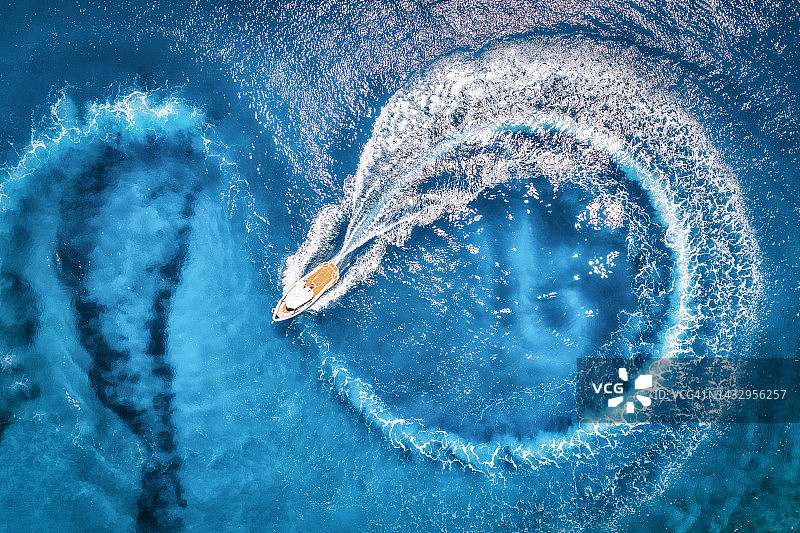 航拍的快艇在透明的蓝色水域在夏天日落。从地中海快速漂浮游艇的无人机俯瞰。热带多彩的风景与摩托艇。极端的图片素材