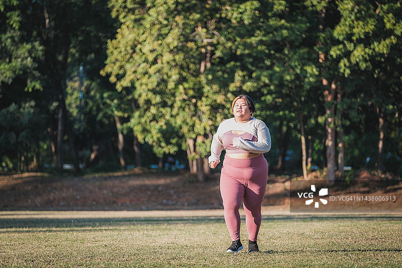 年轻的亚洲超重妇女在公园里慢跑和跑步图片素材
