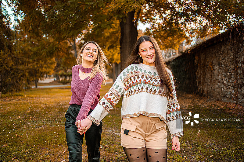 两个女性朋友一起在公园里度过温暖的秋日图片素材