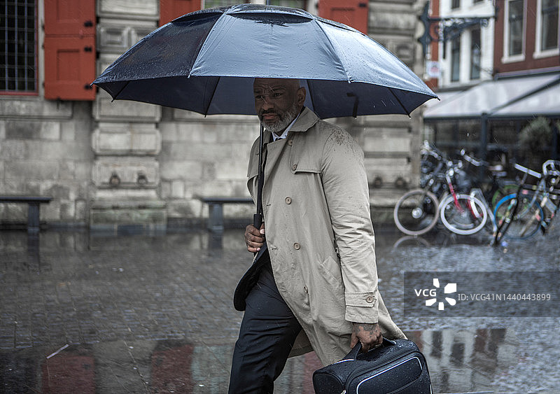 一个雨天，黑人商人在代尔夫特通勤图片素材