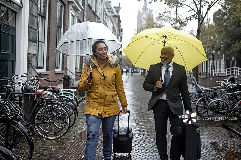 两个多民族旅行家同事在一个雨天在代尔夫特一起通勤图片素材