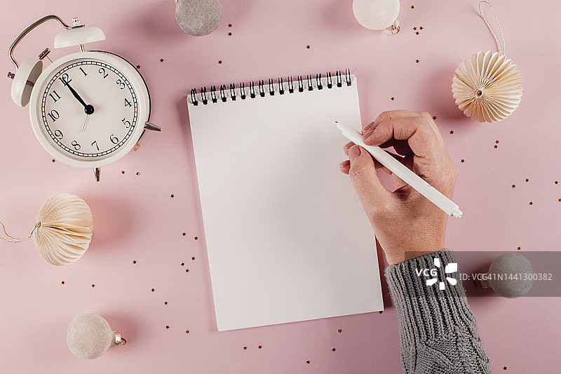 女性手写计划，目标在粉色背景的白色记事本上。正上方图片素材