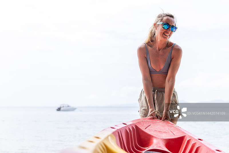 在海滩上划皮艇的年轻女子图片素材