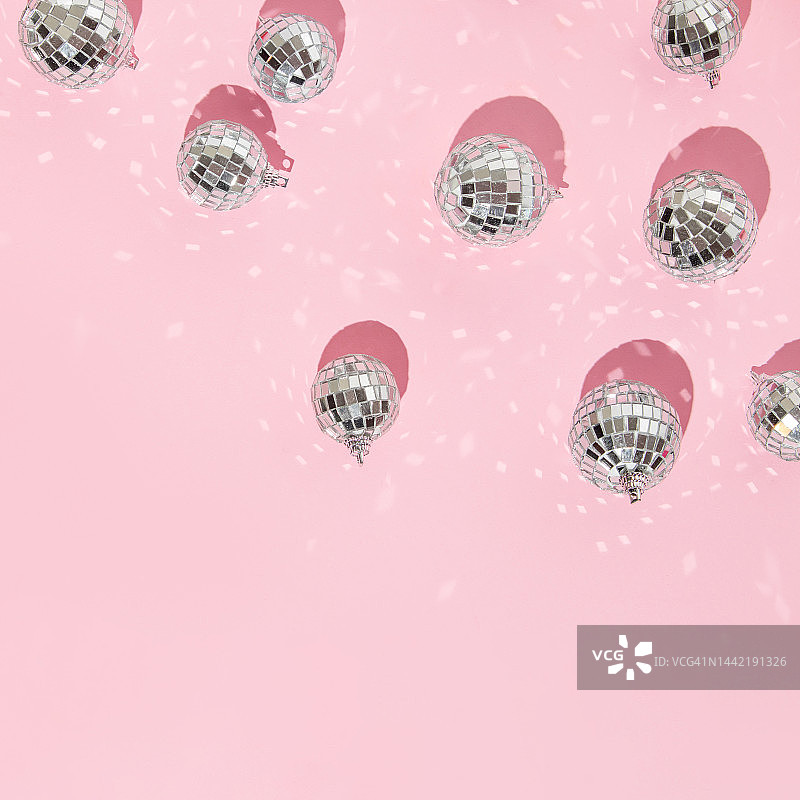 圣诞和新年的创意布局与迪斯科球装饰在柔和的粉色背景。八九十年代的审美时尚假日概念。时髦的简约假日想法。图片素材
