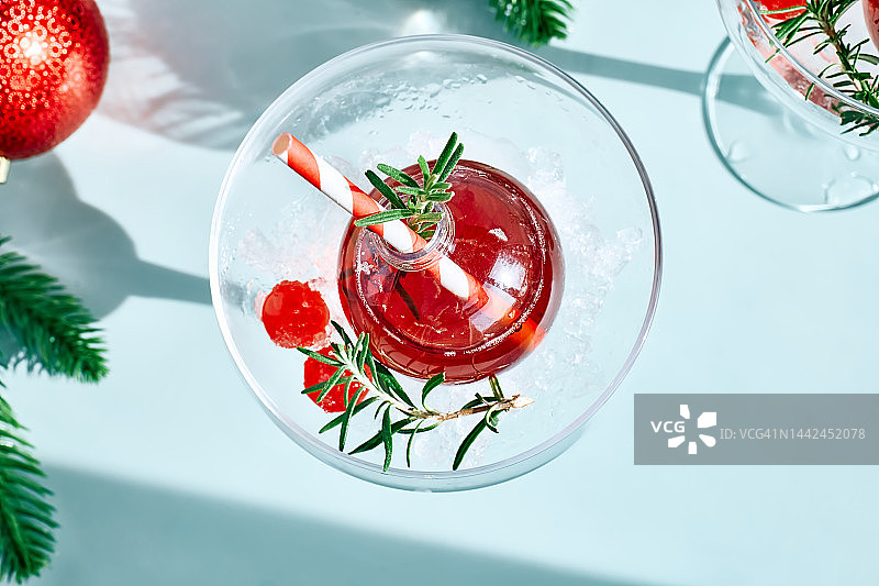 圣诞点心饮料含羞草，潘趣酒或蔓越莓玛格丽塔鸡尾酒服务在圣诞装饰品和马提尼酒杯。圣诞和冬季派对的美味冰饮创意。图片素材
