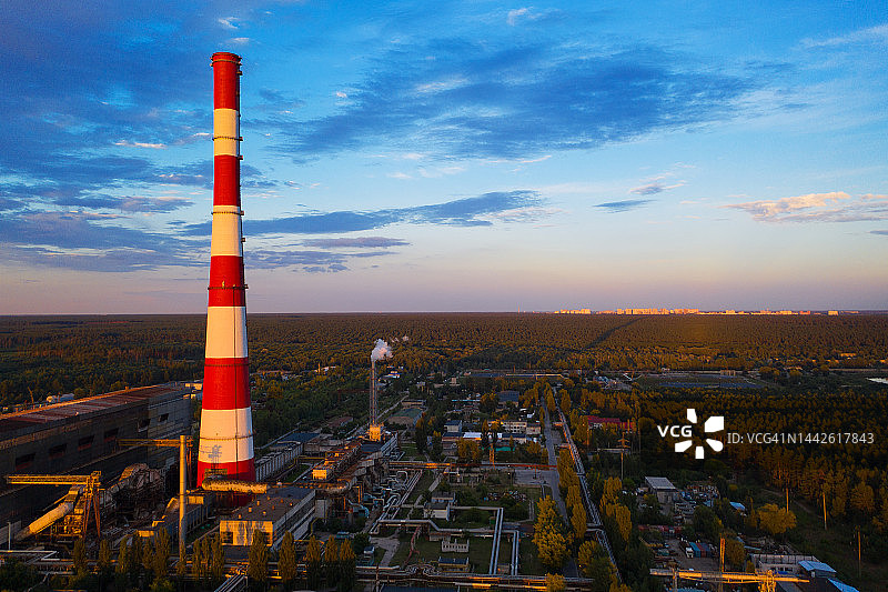 无人机拍摄的电站，工厂红色烟囱在日落的天空图片素材