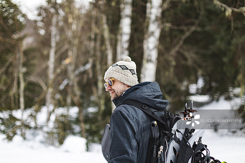 年轻的成年男子带着滑雪板在山区旅游图片素材