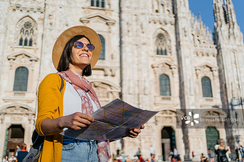 年轻女子在米兰大教堂前使用地图图片素材