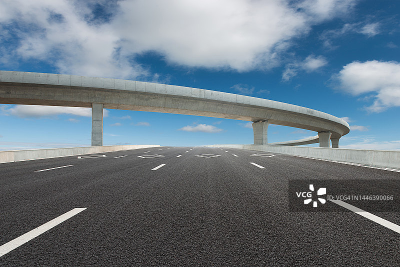 高架桥高速公路通往晴朗天空下的城市图片素材