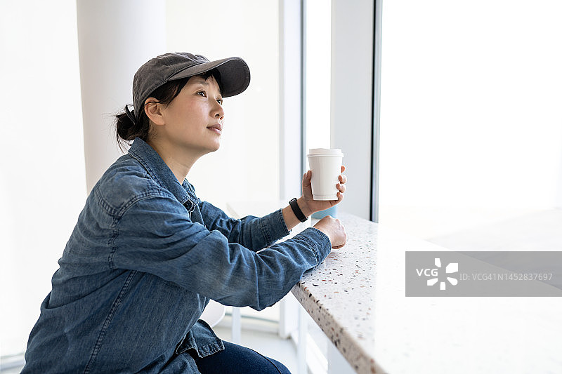 一位城市妇女在咖啡店里喝咖啡图片素材