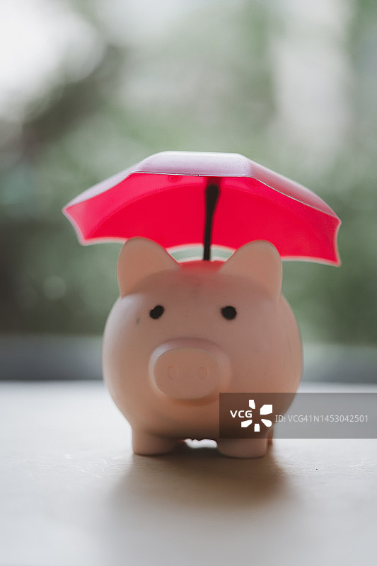 粉红伞存钱罐，理财保险保护理念图片素材