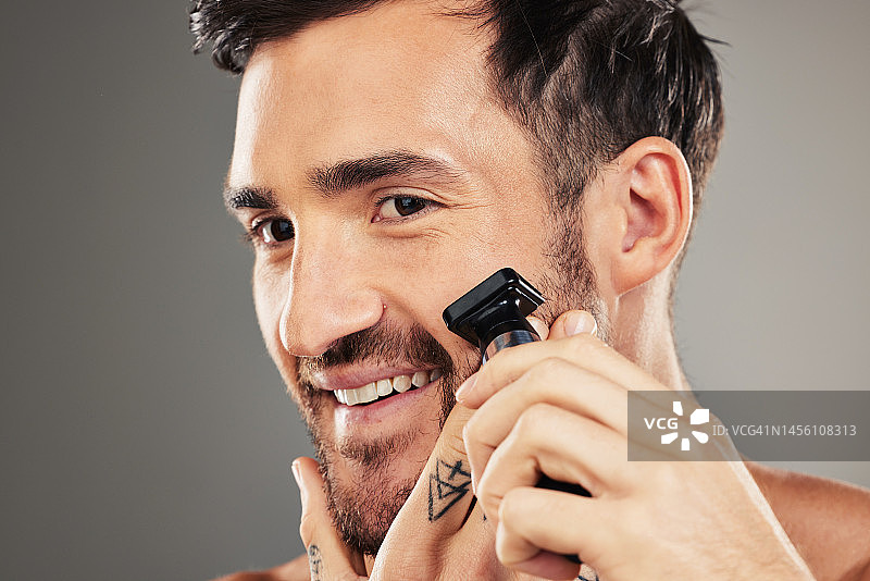 面部，护肤和男子剃须与剃刀在工作室隔离在灰色背景模型。来自澳大利亚的微笑、健康和快乐的男性模特剃须或面部毛发，用于修饰、美容或卫生图片素材
