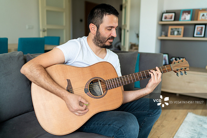 男人在家里弹吉他图片素材