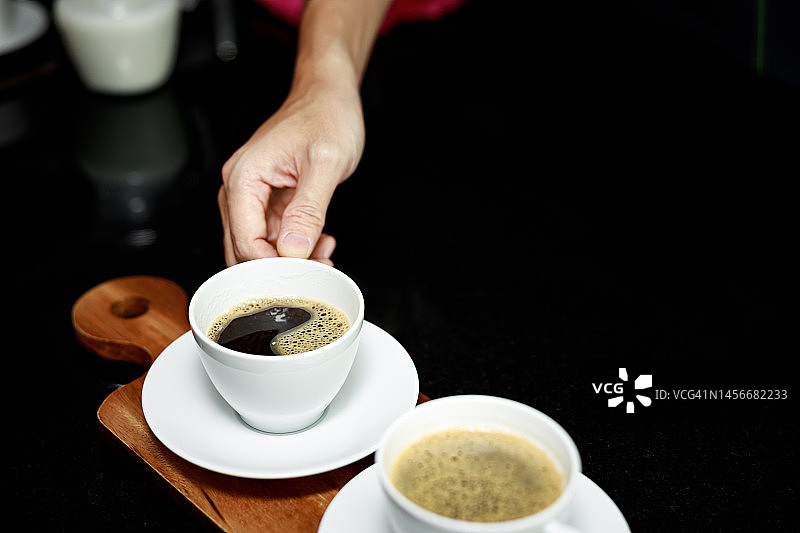盘子上的咖啡杯和手咖啡师图片素材