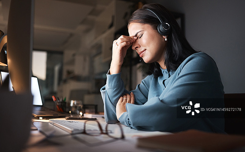 压力、倦怠和加班，呼叫中心的女人在客户关系管理办公桌前头痛。疲惫，沮丧和烦恼的客户服务顾问在电脑工作到深夜与错误或故障。图片素材