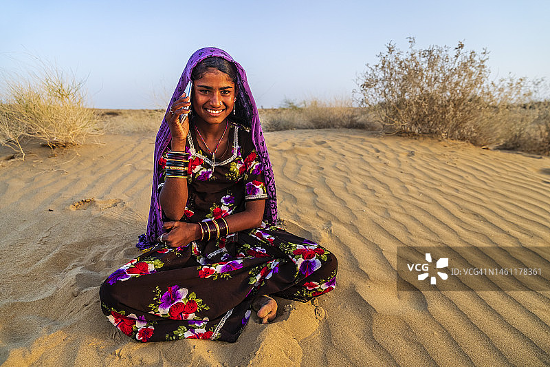 快乐的吉普赛印度女孩使用智能手机，印度图片素材