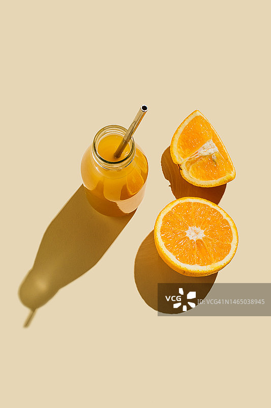 色彩鲜艳的鲜榨橙汁，米色背景的鲜榨橙汁。超级食品，健康食品，饮料，饮食和排毒概念。平铺，俯视图图片素材