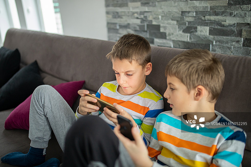 两个男孩在家里玩手机游戏图片素材