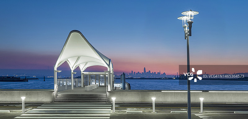 公众客运渡轮码头在日落时由LED节能灯照明。图片素材