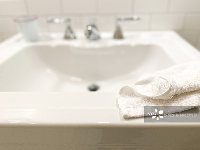 白瓷浴室底座水槽，上面有白色毛巾图片素材
