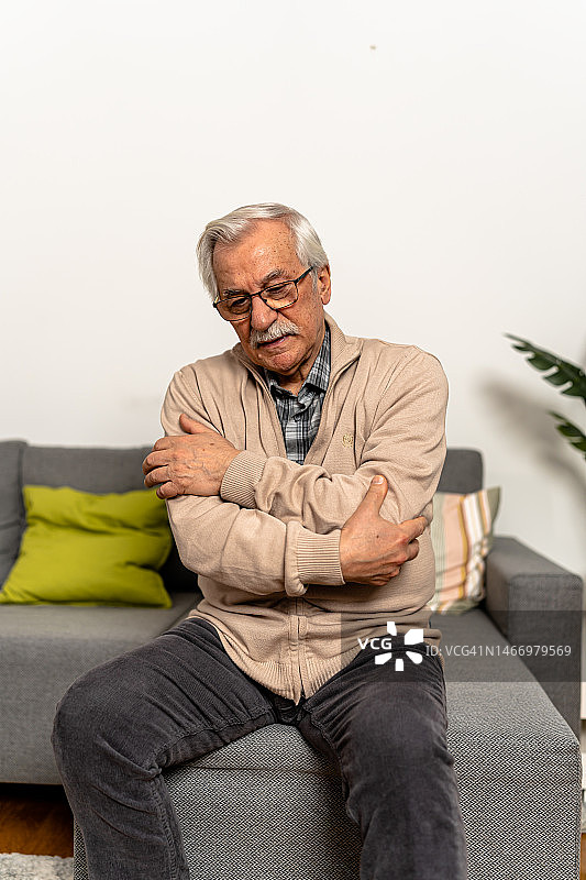 一位患有慢性肘部疾病和慢性疼痛的老年男子的照片。图片素材
